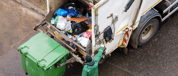 tipper truck being used to collect rubbish by clearance removal man in green jacket